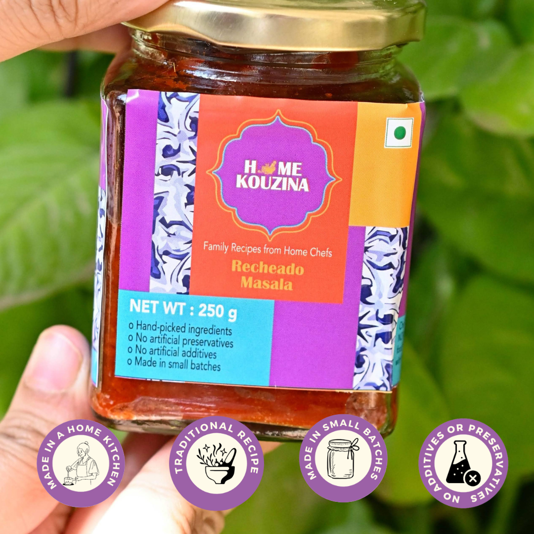 Front view holding Goan Recheado Masala jar in hand, outdoors