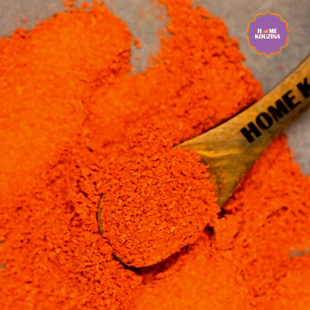 Front view of Home Kouzina Byadgi Chilli Powder spoonful on grey table – small-batch, natural Indian spice with nutritional information and cooking instructions