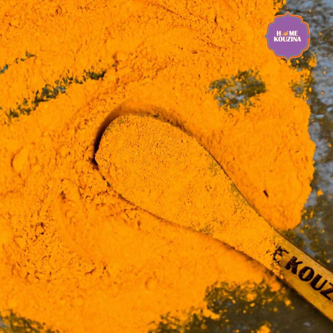 Top view of Home Kouzina Lakadong Turmeric with a wooden spoon with the powder on grey table
