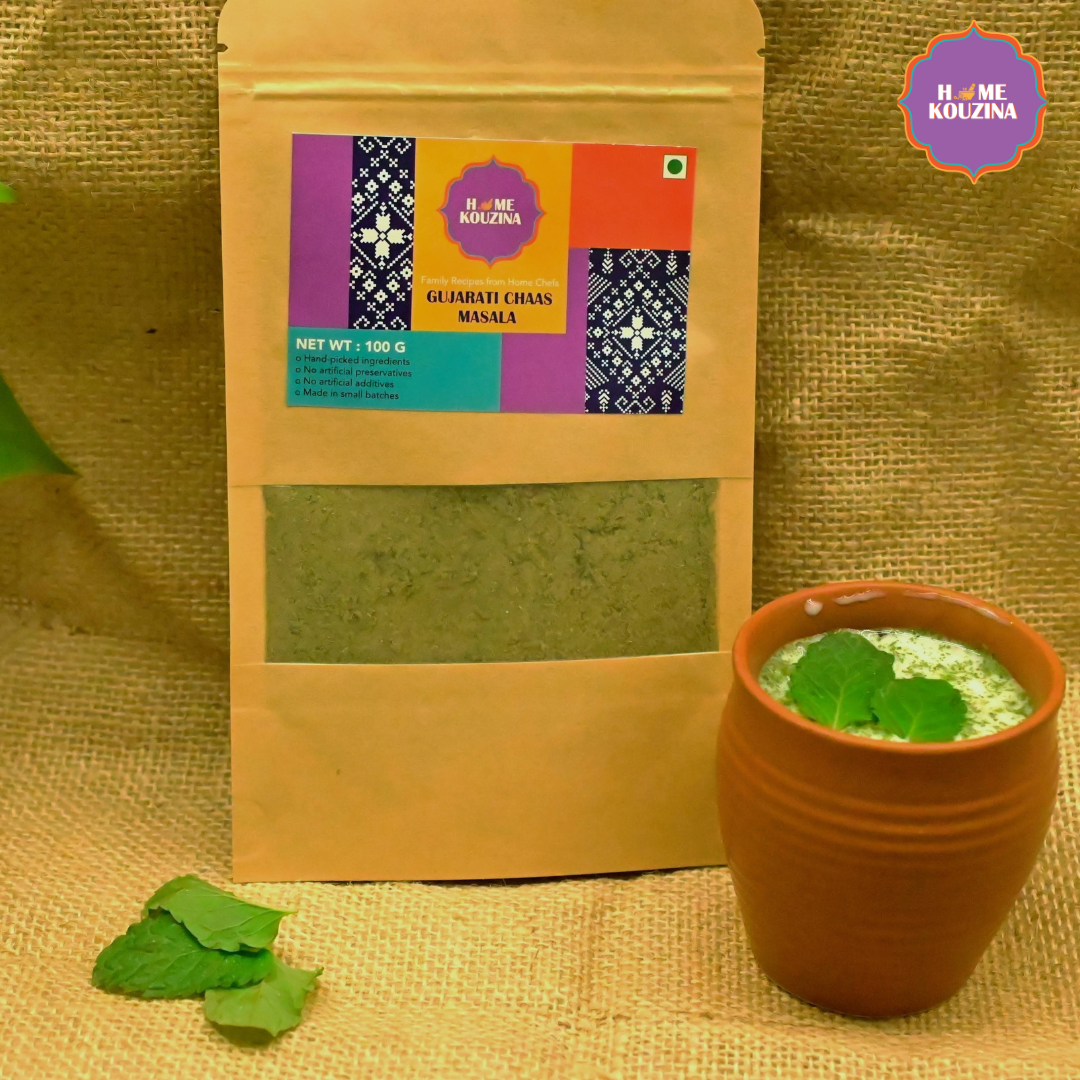 Home Kouzina Gujarati Chaas Masala 100g pouch placed next to glass of chaas in a traditional glass garnished with mint – traditional Indian summer refresher