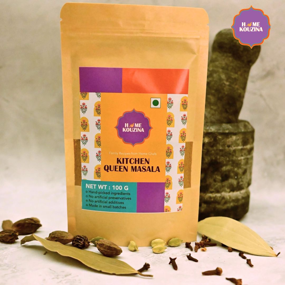 Home Kouzina Kitchen Queen Masala 100g pouch – versatile spice blend for dal, khichdi, dry sabzis, and more, perfect for fuss-free flavorful cooking placed in front of a traditional mortar and pestle