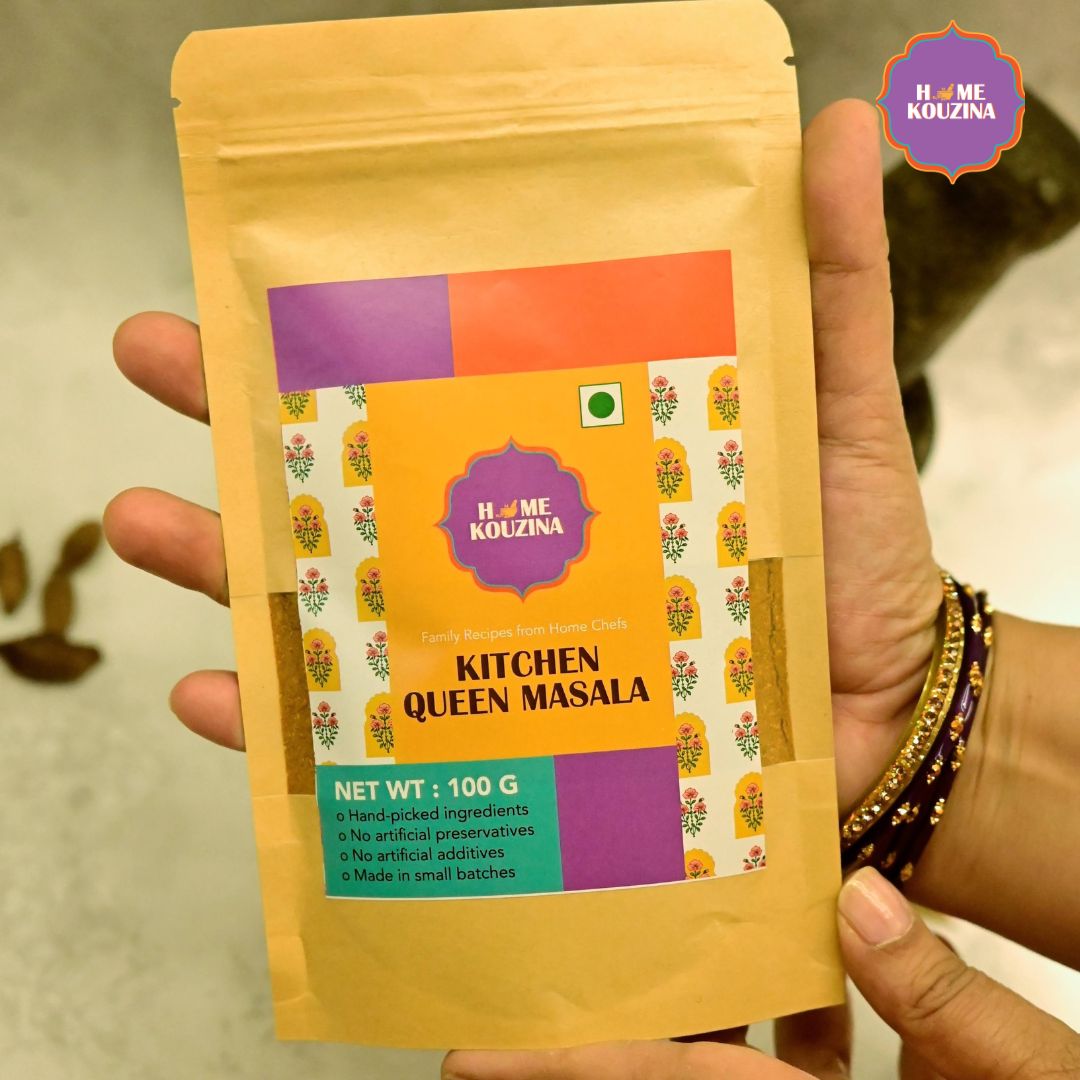 Closeup of holding Home Kouzina Kitchen Queen Masala 100g pouch