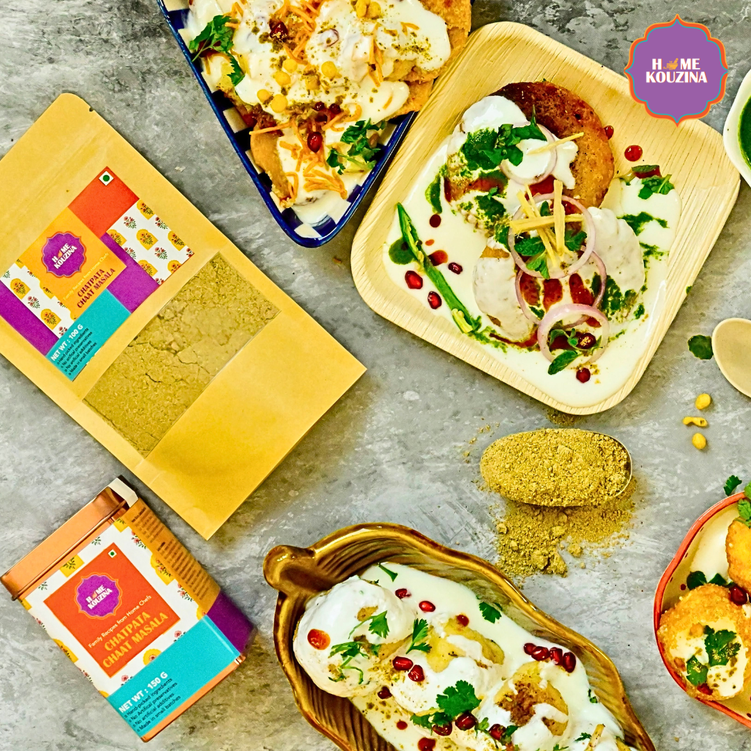 Top view of Home Kouzina Chatpata Chaat Masala 100g pouch and 150g tin with platter of papdi chaat on grazing board – zesty, tangy, and authentic Old Delhi street-style spice blend