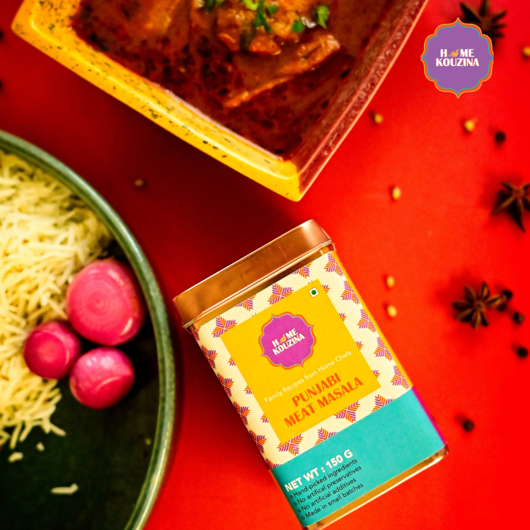 Top view of Home Kouzina Punjabi Meat Masala 150g tin next to prepared meat gravy, plate of rice, and pickled onions – traditional Punjabi curry spice blend