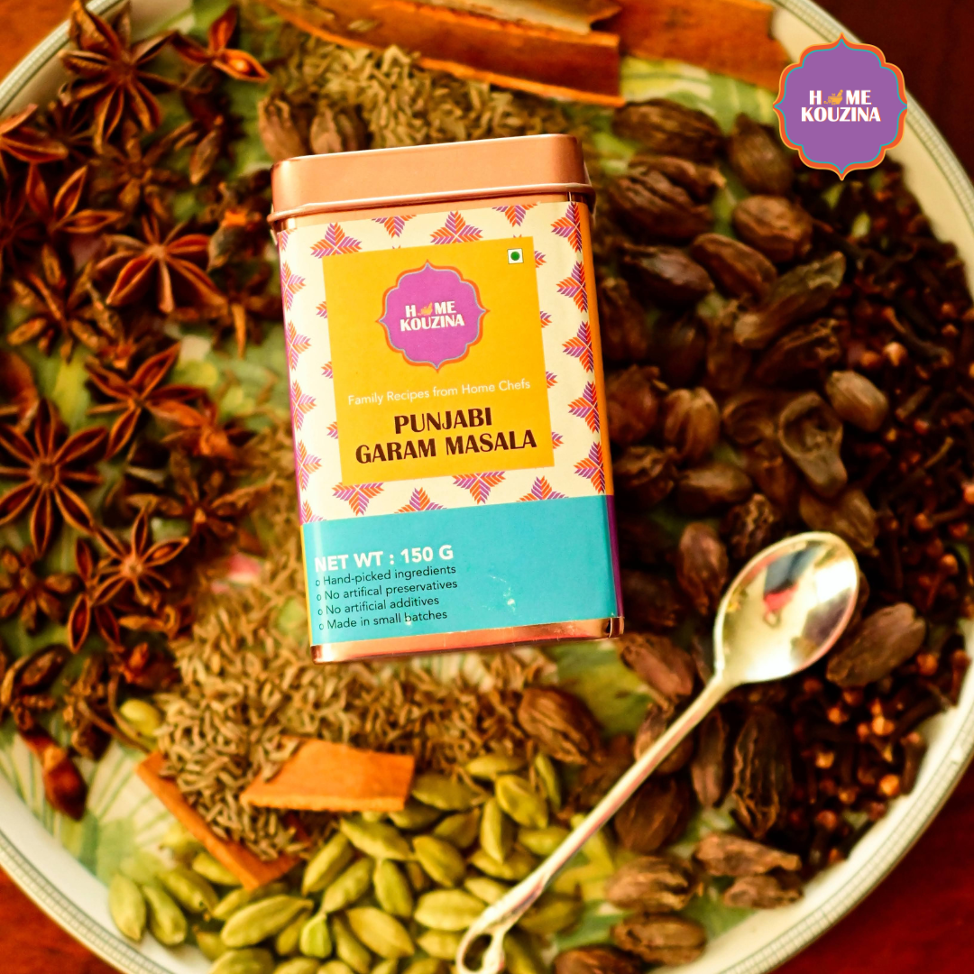 Top view of Home Kouzina Punjabi Garam Masala 150g tin placed on a plate full of whole spices – handcrafted, small-batch North Indian spice blend