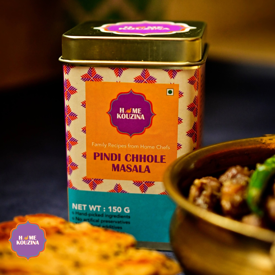 Top view of Home Kouzina  Pindi Chhole Masala placed on table next to prepared bowl of Pindi chhole and Kulcha
