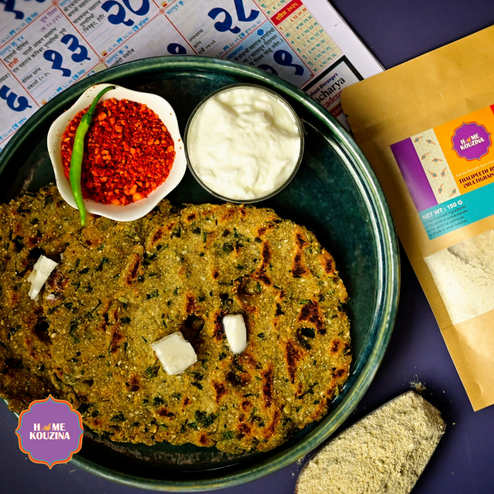Plate of Maharashtrian Thalipeeth served with shengdana chutney, curd and butter with multi grain flour on a scoop