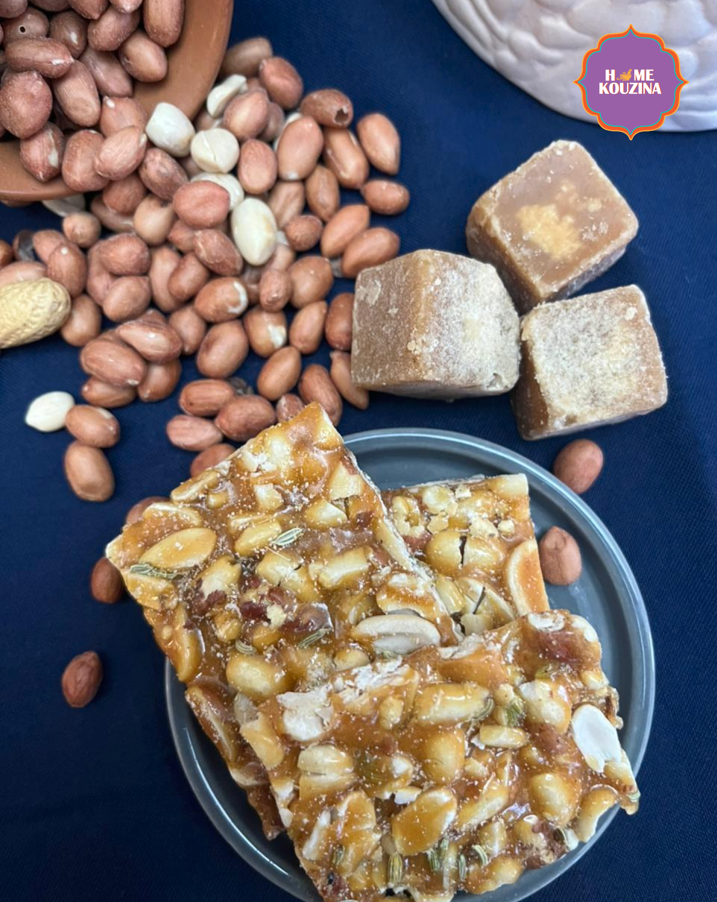 Nuts and a nut-based candy on a blue surface with 'Me Kuzina' branding.